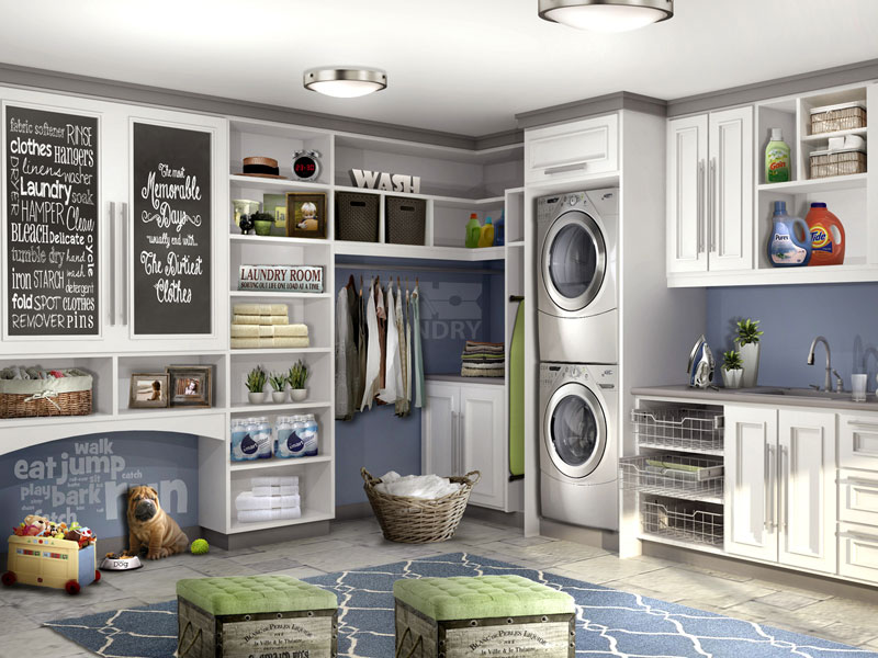 Large laundry room with stackable washer and dryer has custom designed and built cabinets on two walls.